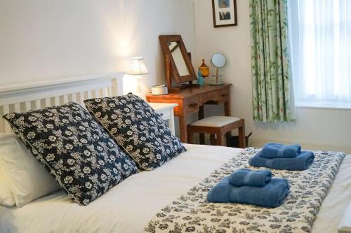 a bedroom with a bed with two blue towels on it at Heart of Totnes, Period Property in Dean