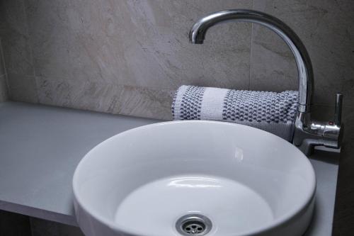 a white sink with a faucet in a bathroom at Porto Evia Boutique Hotel in Amarinthos