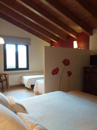 a bedroom with two beds and two roses on the wall at Les Flors - Hotel Rural & Cabanyes in Gramós