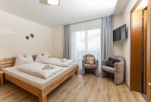 a hotel room with a bed and a chair at Appartements Lettmayer by Schladming Appartements in Schladming