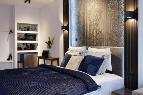 1 dormitorio con 1 cama con almohadas azules y blancas en Limani's Sea View Deluxe, en Tesalónica