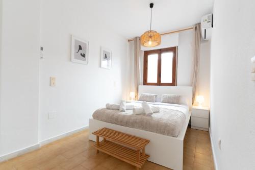a white bedroom with a bed and a window at Beach Apartment Green Terrace La Mata in Torrevieja