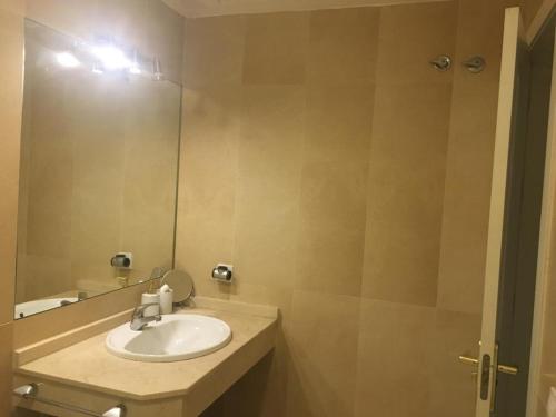 een badkamer met een wastafel en een spiegel bij Áncora apartamento in El Puerto de Santa María