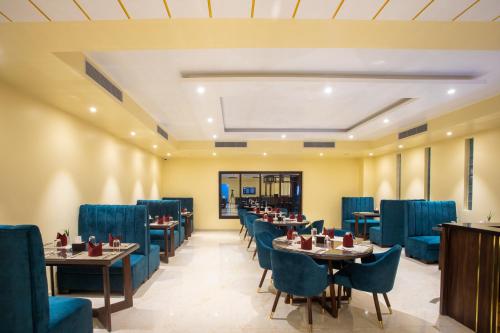 a restaurant with blue chairs and tables in a room at Bhairahawa Garden Resort in Lumbini