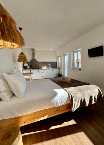 a large bed in a room with a kitchen at Fishermans House in Almograve