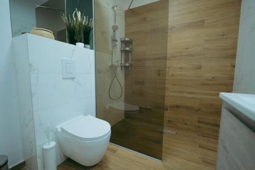 a white bathroom with a toilet and a shower at House by the Lake 7 in Bucharest
