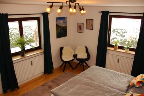 1 Schlafzimmer mit 2 Stühlen und 2 Fenstern in der Unterkunft Allgäu Retreat in Bad Wörishofen