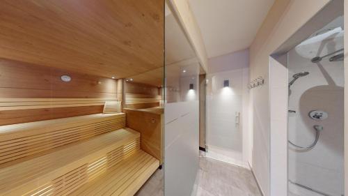 a sauna with wood paneling and a shower at Hotel Pension Haid in Sankt Leonhard im Pitztal