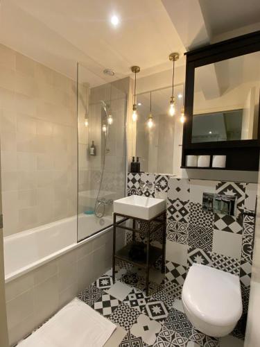 une salle de bain avec toilettes, lavabo et baignoire dans l'établissement Charming studio near Tour Eiffel Invalides Beaugrenelle, à Paris
