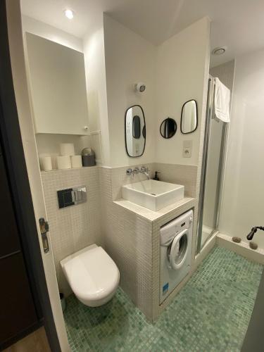une petite salle de bain avec toilettes et lavabo dans l'établissement Cozy studio 10 min from Eiffel Tower Invalides Beaugrenelle, à Paris