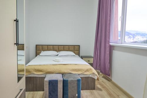 a bedroom with a bed and a mirror at Hotel Lile • სასტუმრო ლილე in Khulo