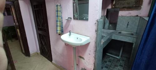La salle de bains est pourvue d'un lavabo et d'un miroir. dans l'établissement Mandeep Home Stay, à Kapkot