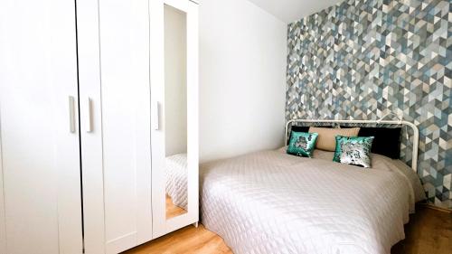 a small bedroom with a bed and a mirror at Cosy Living Apartment w Balcony in Budapest