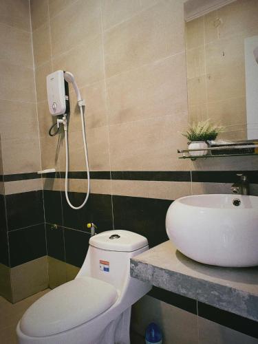 La salle de bains est pourvue de toilettes et d'un lavabo. dans l'établissement Flower Home ផ្ទះសំណាក់ ហូមផ្កា, à Sihanoukville