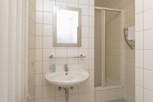 Baño blanco con lavabo y espejo en Appartements Maria Stewart by Schladming-Appartements, en Schladming