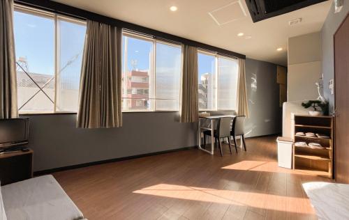 a bedroom with large windows and a table with chairs at Tomi Home 2F in Tokyo