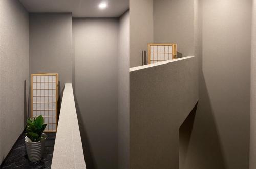 a hallway with a wall with a shelf and a plant at Tomi Home 2F in Tokyo