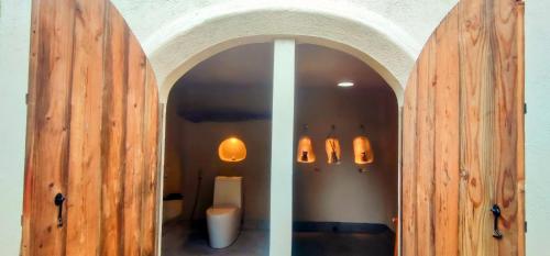 La salle de bains est pourvue de toilettes par une porte en bois. dans l'établissement Firesky Glamping Ocam Ocam Beach, à New Busuanga