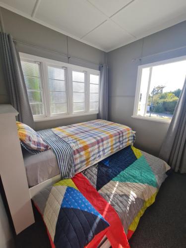 um quarto com 2 camas e uma janela em Entire 3 bedroom house 2000 m2 - 5 mins WALK to Torquay Beach, Hervey Bay em Hervey Bay