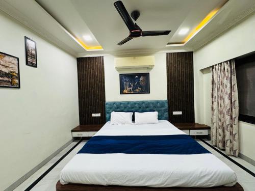 a bedroom with a bed and a ceiling fan at Kadwali Villa with Private Pool in Ujjain
