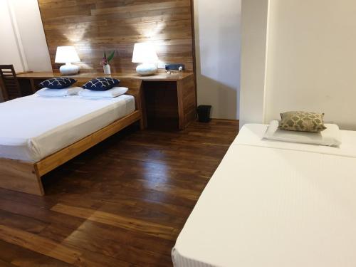 a bedroom with two beds and a desk with two lamps at Giri Villa in Tangalle