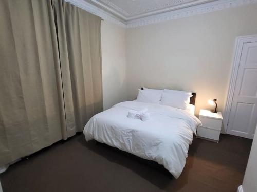 1 dormitorio con cama blanca con arco en 2 Bedroom Flat - both rooms are ensuite, en Elswick