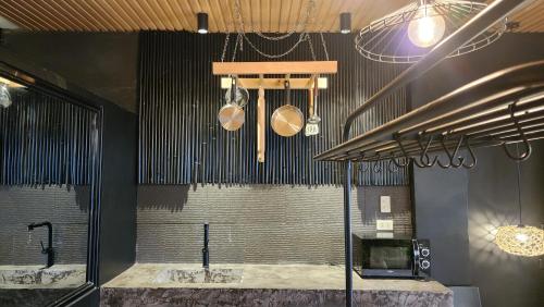 エルニドにあるThe Designer Glasshaus - Glamping at Karuna El Nidoの鍋と鍋が天井からぶら下がるキッチン付き