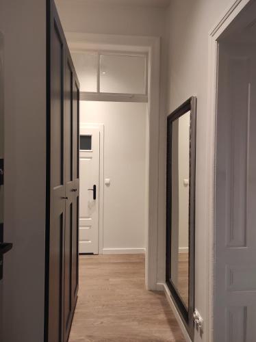 um corredor vazio com um espelho e uma porta em Chabrowy - Apartamenty Smart Projekt em Tarnów