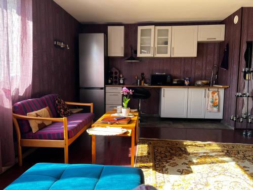 een keuken en een woonkamer met een bank en een tafel bij Luxurious En-suit room with Sauna in Pyussi