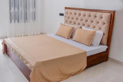 a bedroom with a bed with a padded headboard and pillows at Muthu Villa 94 Midigama in Ahangama East