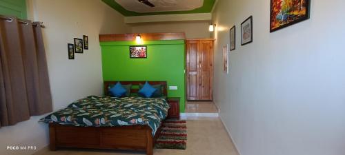 een slaapkamer met een bed en een groene muur bij The Moon Light Home stay in Bhīm Tāl