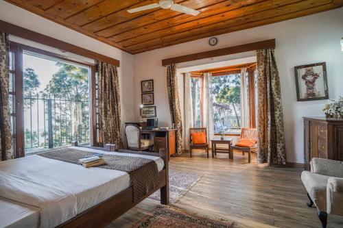 a bedroom with a bed and a large window at SaffronStays The Perch in Kasauli