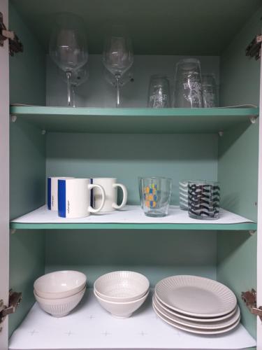 a shelf with plates and wine glasses and dishes at Cozy Private Home Newly Renovated in Seoul