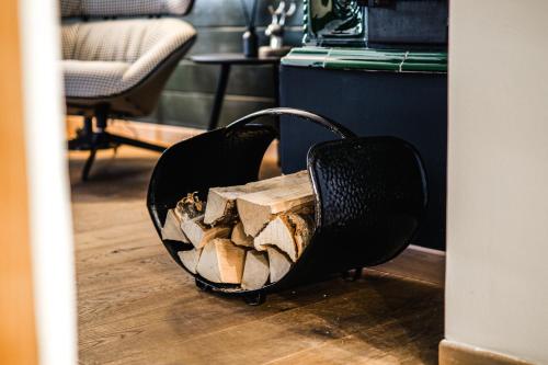 una cesta llena de madera en el suelo de una habitación en Bauernhaus 128 - Boutiquestube 1 Oberkirchleitn by S4Y, en Sankt Oswald