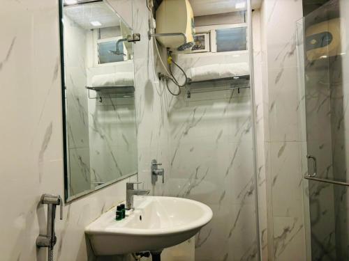 a white bathroom with a sink and a mirror at Hotel Elite By Signature Group in Hyderabad