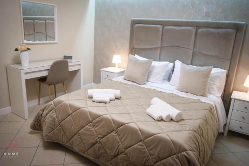 sypialnia z dużym łóżkiem z ręcznikami w obiekcie Home Luxury w mieście Napoli