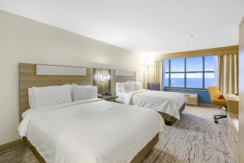 a hotel room with two beds and a window at Holiday Inn Express - Gulfport Beach by IHG in Gulfport