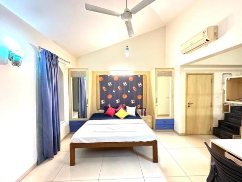 Schlafzimmer mit einem Bett und einem Deckenventilator in der Unterkunft WHITEVILLA 5 ROOMS in Pune