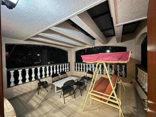 Zimmer mit einem Tisch und Stühlen auf einem Balkon in der Unterkunft WHITEVILLA 5 ROOMS in Pune