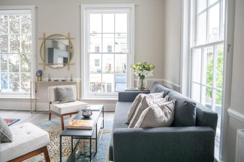 een woonkamer met een bank en een tafel bij Spectacular flat located in prime Notting Hill in Londen