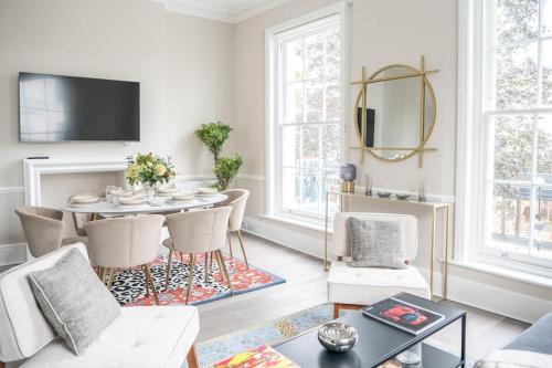 een woonkamer met een tafel en stoelen bij Spectacular flat located in prime Notting Hill in Londen