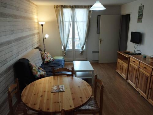 a living room with a table and a couch at Appartement 5 personnes centre de Luchon in Luchon