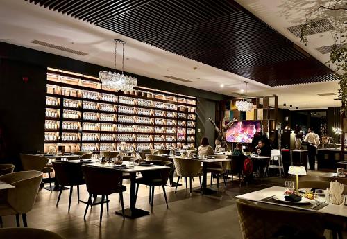 un restaurante con mesas y sillas y una gran biblioteca en Dream Studio Silver Mountain, en Poiana Brasov