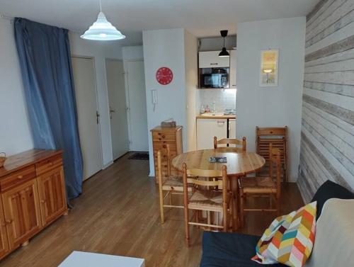 un salon avec une table et une cuisine dans l'établissement Appartement 5 personnes centre de Luchon, à Luchon