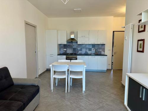 eine Küche und ein Wohnzimmer mit einem Tisch und Stühlen in der Unterkunft Casa Maestrale - Elegante con Balcone Vista Mare in Finale Ligure