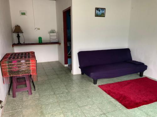 a living room with a blue couch and a red rug at Mario Lakeside Apartments in Tuktuk Siadong