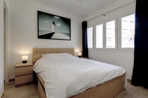 - une chambre avec un grand lit blanc et un phare dans l'établissement 028- CHU Hôpital, Appart 2chambres, Parking, Tram, à Montpellier