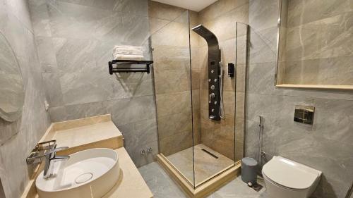 a bathroom with a shower and a toilet and a sink at Grand Room in Sheikh Zayed