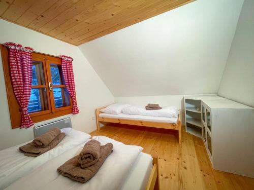 two beds in a room with a window and a bed sqor at Traditional deer Cabin with Sauna in Dolný Kubín