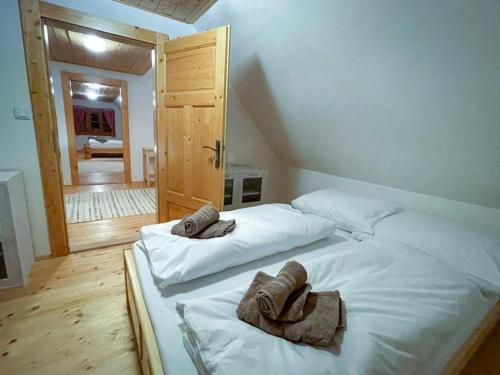 a bedroom with a bed with towels on it at Traditional deer Cabin with Sauna in Dolný Kubín